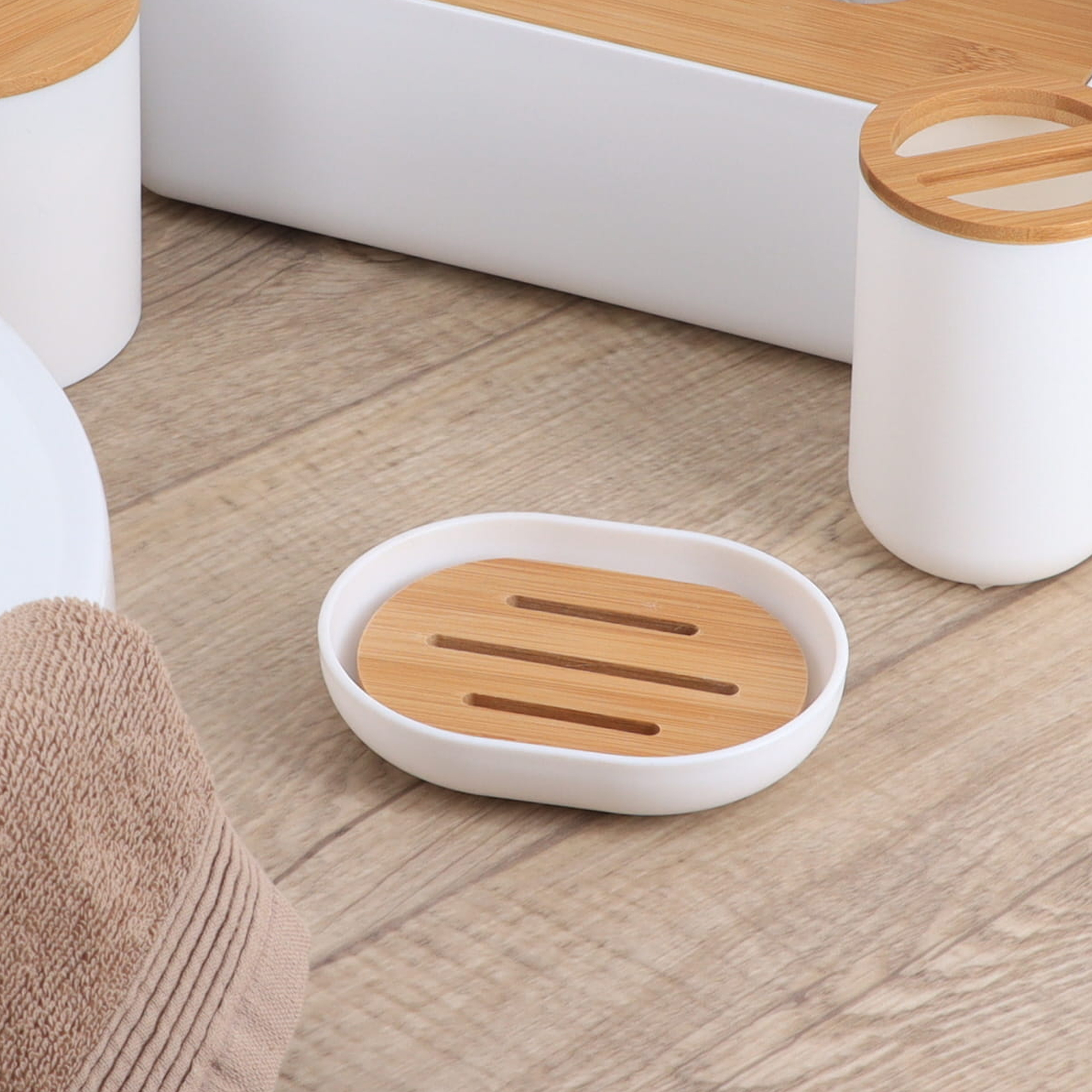White bamboo soap dish placed on bathroom wood floor near accessories