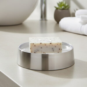 Bar soap resting on brushed aluminum soap dish on vanity