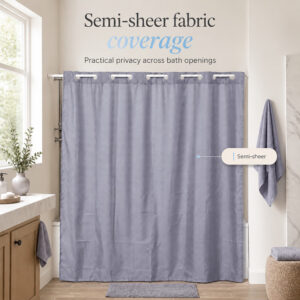 Semi-sheer gray shower curtain giving privacy across a bathtub opening in a bright bathroom with a window