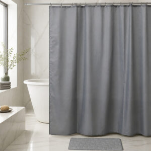 Grey polyester shower curtain installed across a bathtub in a hotel style bathroom