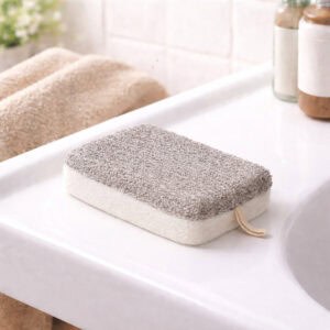 Beige and white exfoliating pad on white bathroom tray