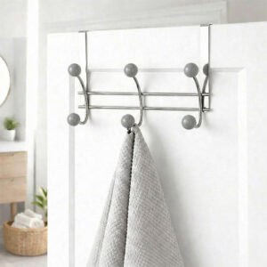 "Chrome over-the-door hook rack with gray ball ends holding gray towel on white bathroom door"