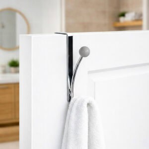 "Chrome over-the-door hook with gray ball end holding white towel on white bathroom door"
