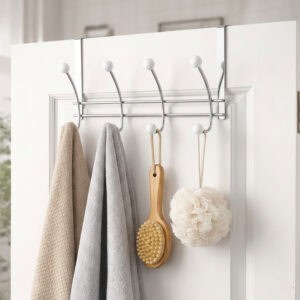 "Chrome over-the-door hook rack holding towels, bath brush, and loofah on white bathroom door"
