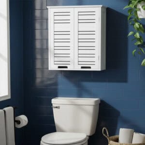 "White double-door louvered wall cabinet mounted above a toilet against a dark blue tiled wall"