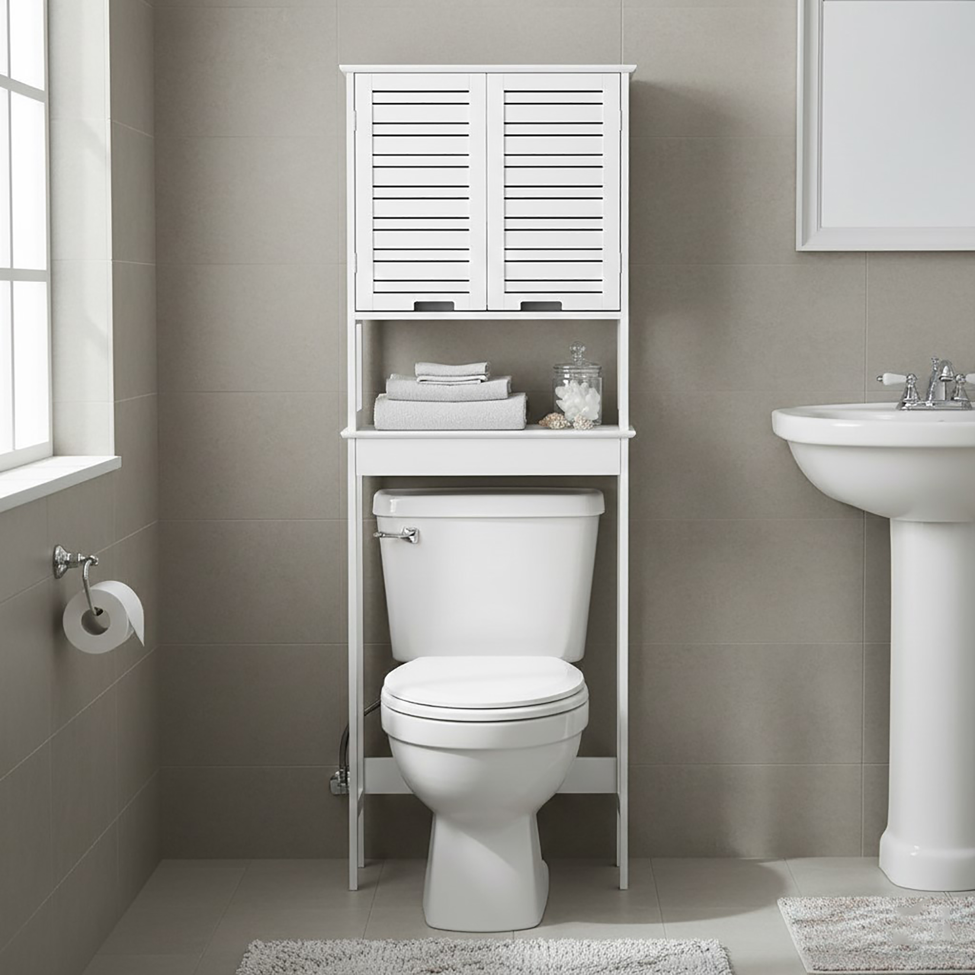 “White over-the-toilet cabinet with closed slatted doors above toilet in neutral bathroom”