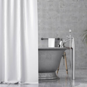 White shower curtain partially covering freestanding bathtub in grey bathroom