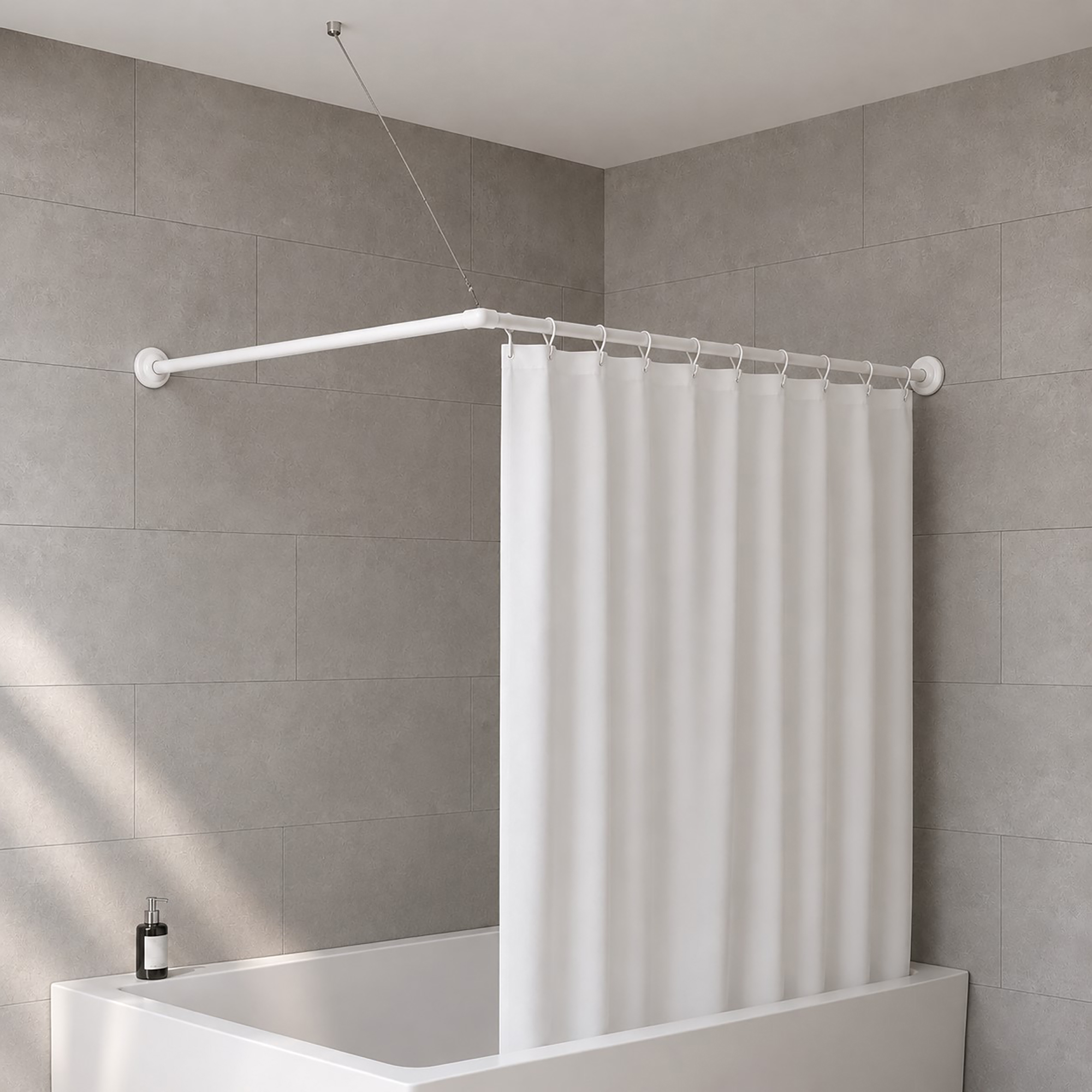 White L-shaped corner shower rod installed in modern gray tile bathroom with closed white curtain over corner bathtub