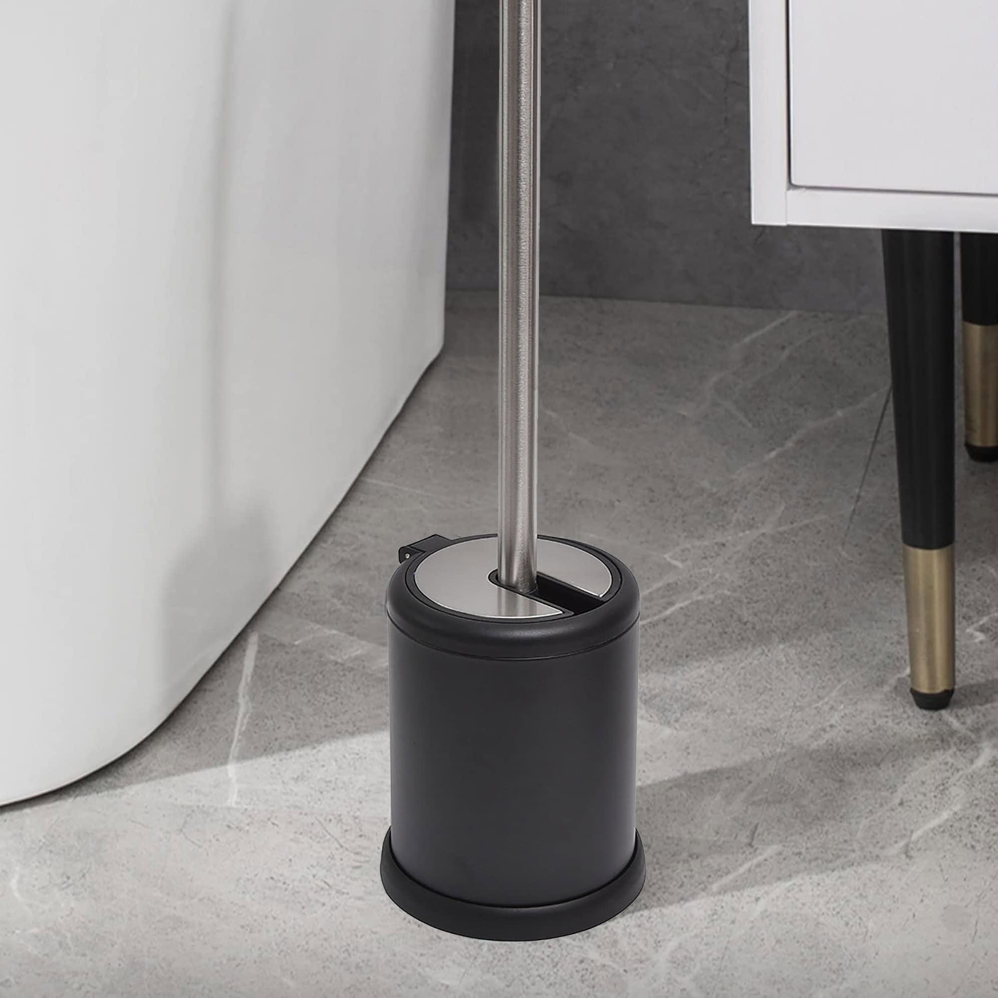 Compact black toilet brush holder with stainless steel handle in a stylish bathroom setting.