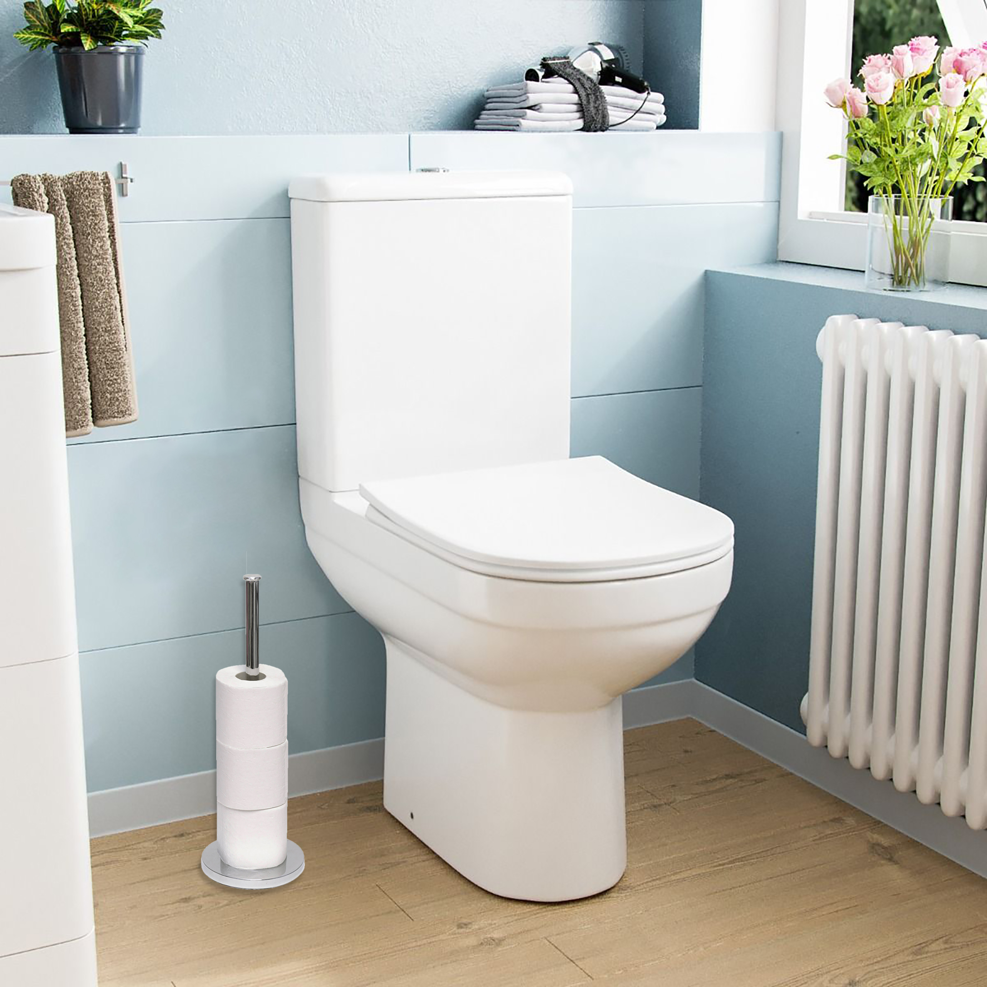 Silver toilet paper holder next to a modern toilet in a bright, stylish bathroom