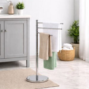 "Chrome 3-arm towel rack holding white, beige, and green towels in bright bathroom"