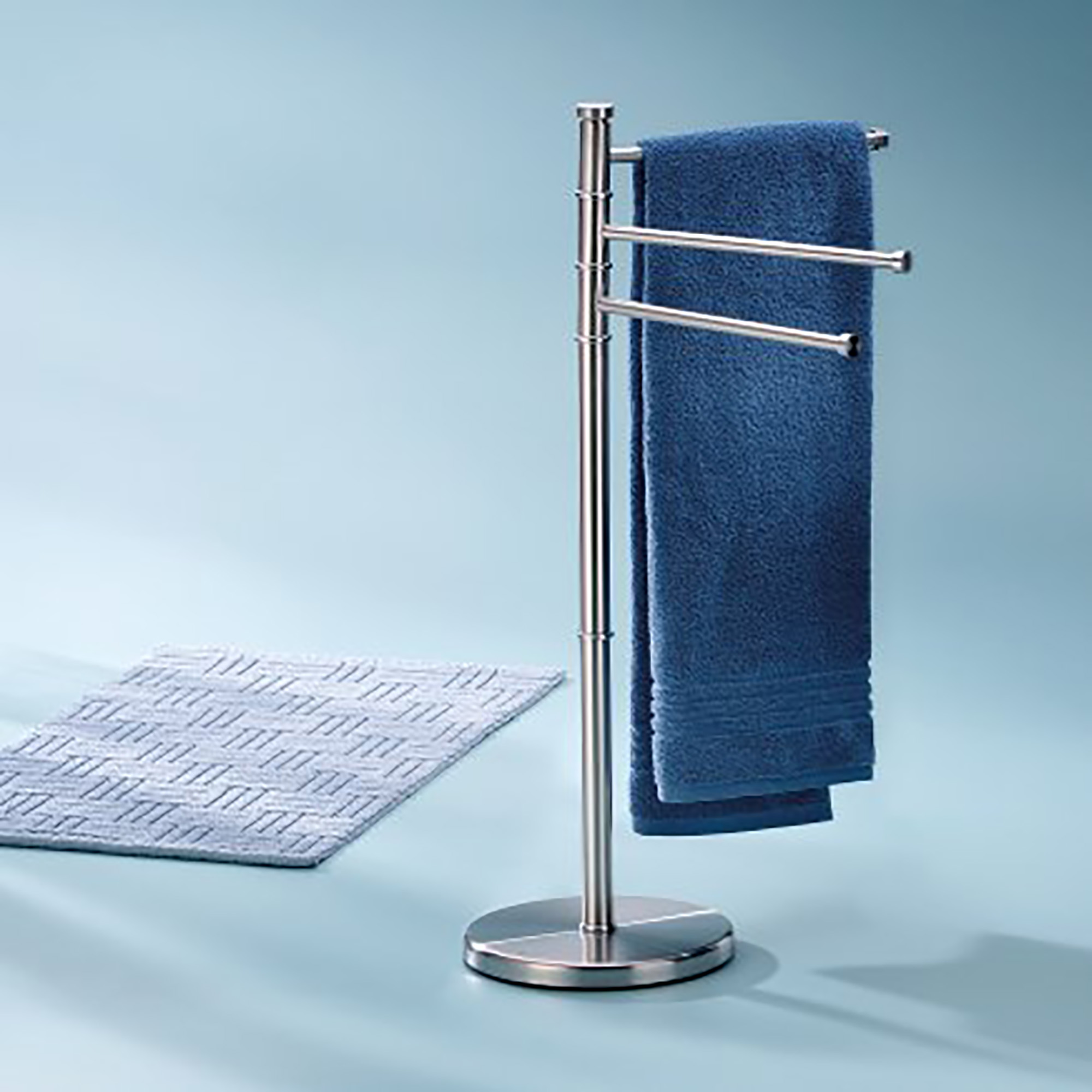 Chrome towel rack holding blue towel in a light blue modern bathroom setting