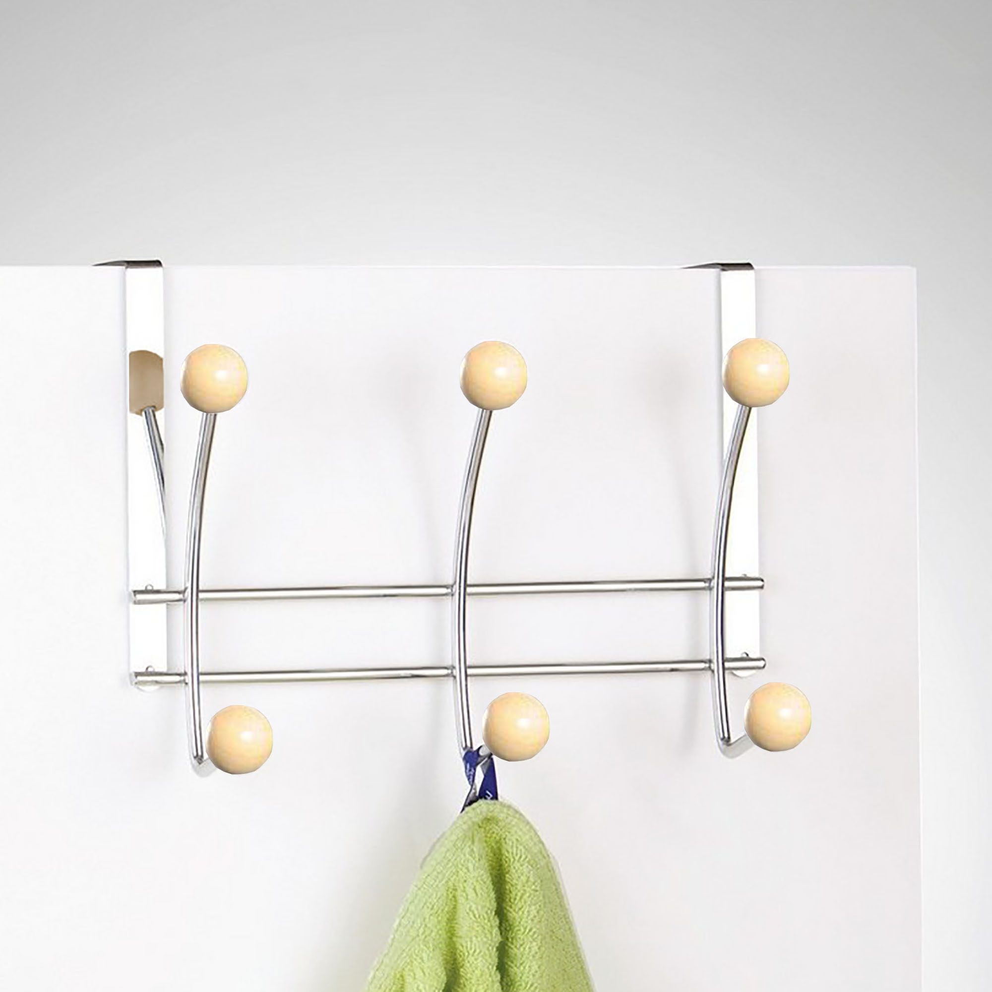 Chrome hook rack hanging on white door holding green towel