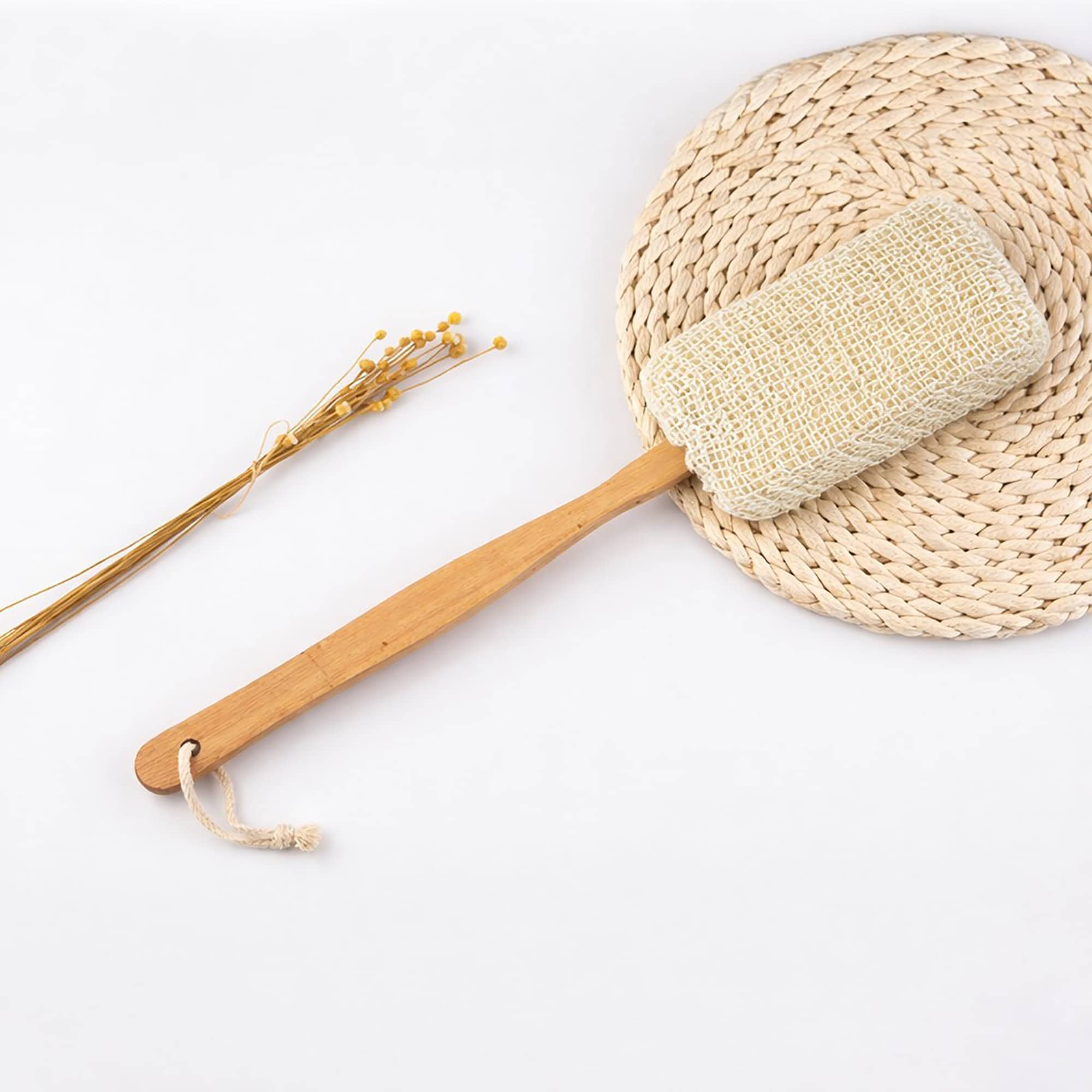 Natural loofah back scrubber displayed with dried flowers and woven basket