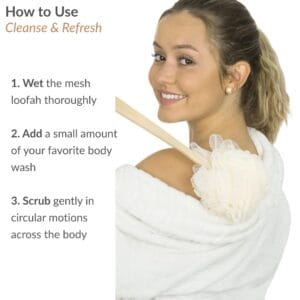 Woman in white robe demonstrating how to use the body brush on her shoulder