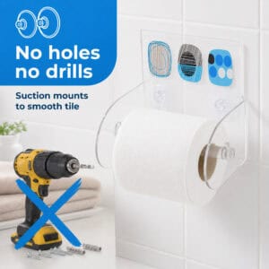 Street Art clear acrylic toilet paper holder on tile holding a white roll, with a crossed-out drill. "No holes no drills" / "Suction mounts to smooth tile".