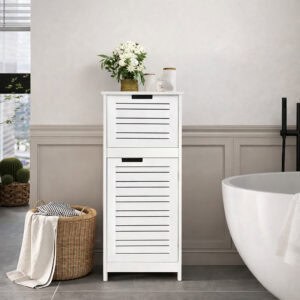 White slatted two-door bathroom floor cabinet with white flowers and accessories on top, beside a freestanding bathtub in a styled bathroom