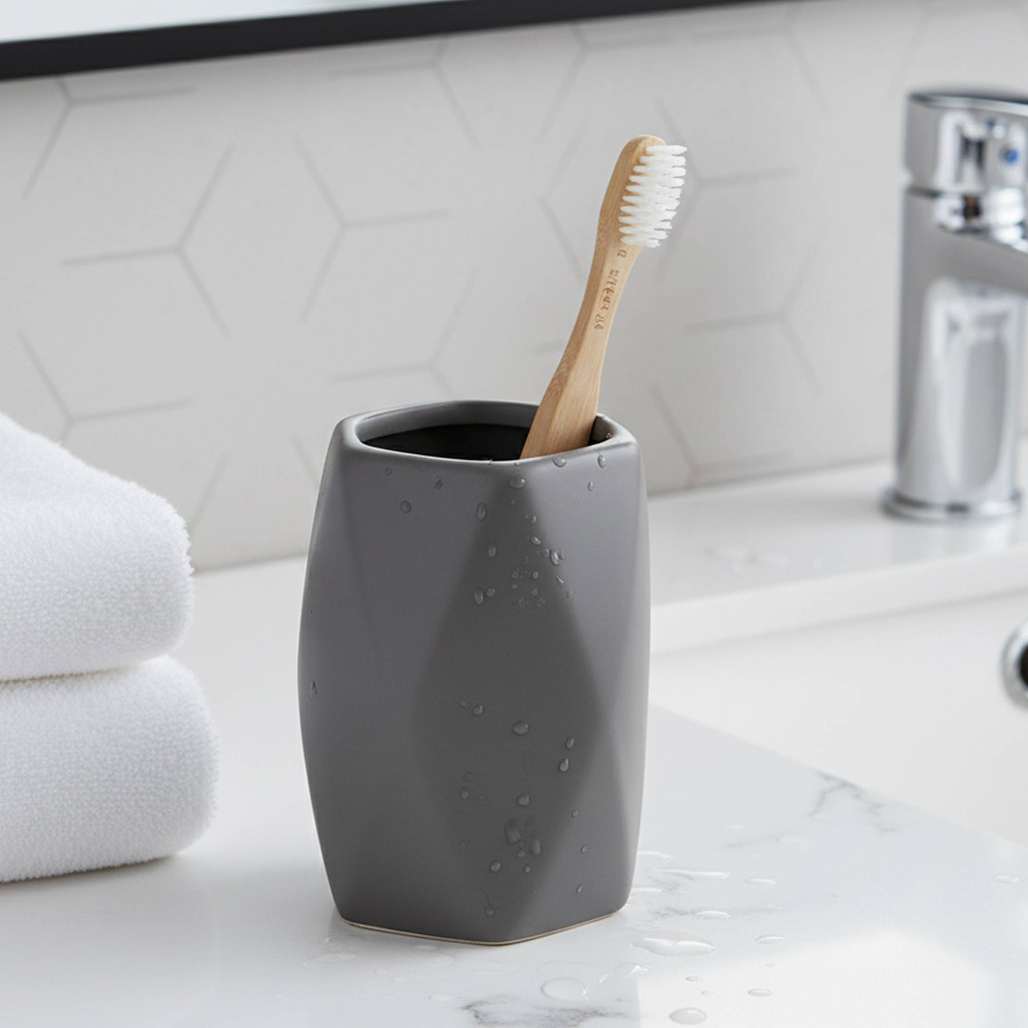 Matte gray stoneware bathroom tumbler with toothbrush on vanity