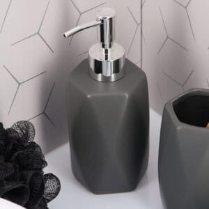Close-up of matte gray soap dispenser with chrome pump