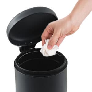 Soft close black bathroom trash can open lid with hand placing tissue