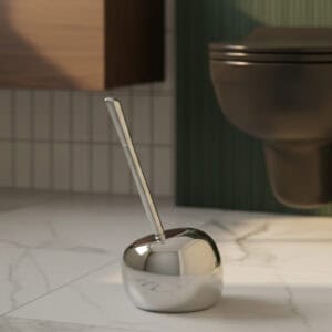 Chrome spherical toilet brush holder with stainless steel handle in contemporary bathroom with green wall
