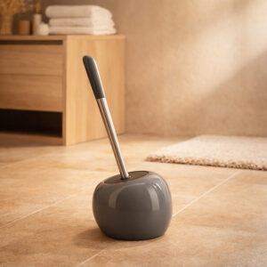 Grey round dolomite toilet brush holder with stainless steel handle in warm bathroom setting