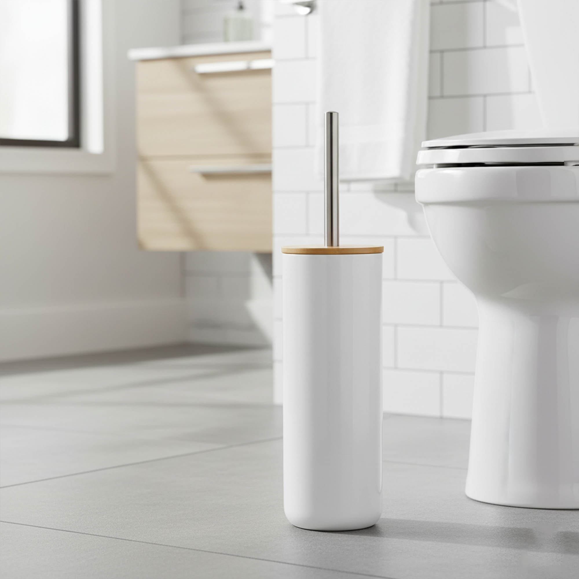 White toilet brush with bamboo lid and stainless steel handle beside white toilet in modern bathroom
