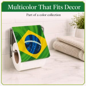 Brazil flag print toilet paper holder mounted on white subway tile holding a white roll under a flip-up Brazilian flag cover, styled with towels and a plant. "Multicolor That Fits Decor" / "Part of a color collection".