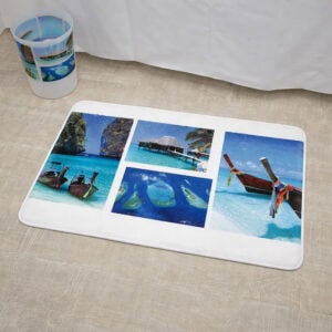 Close-up of paradise print bath mat on wood-look floor beside bathtub with matching wastebasket