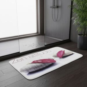 "'Zen attitude' bath mat placed outside glass shower door on dark wood floor"