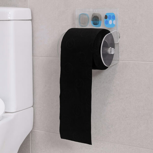 Street Art clear acrylic toilet paper holder suction-mounted on grey tile beside a toilet tank, holding a black roll with paper hanging down.