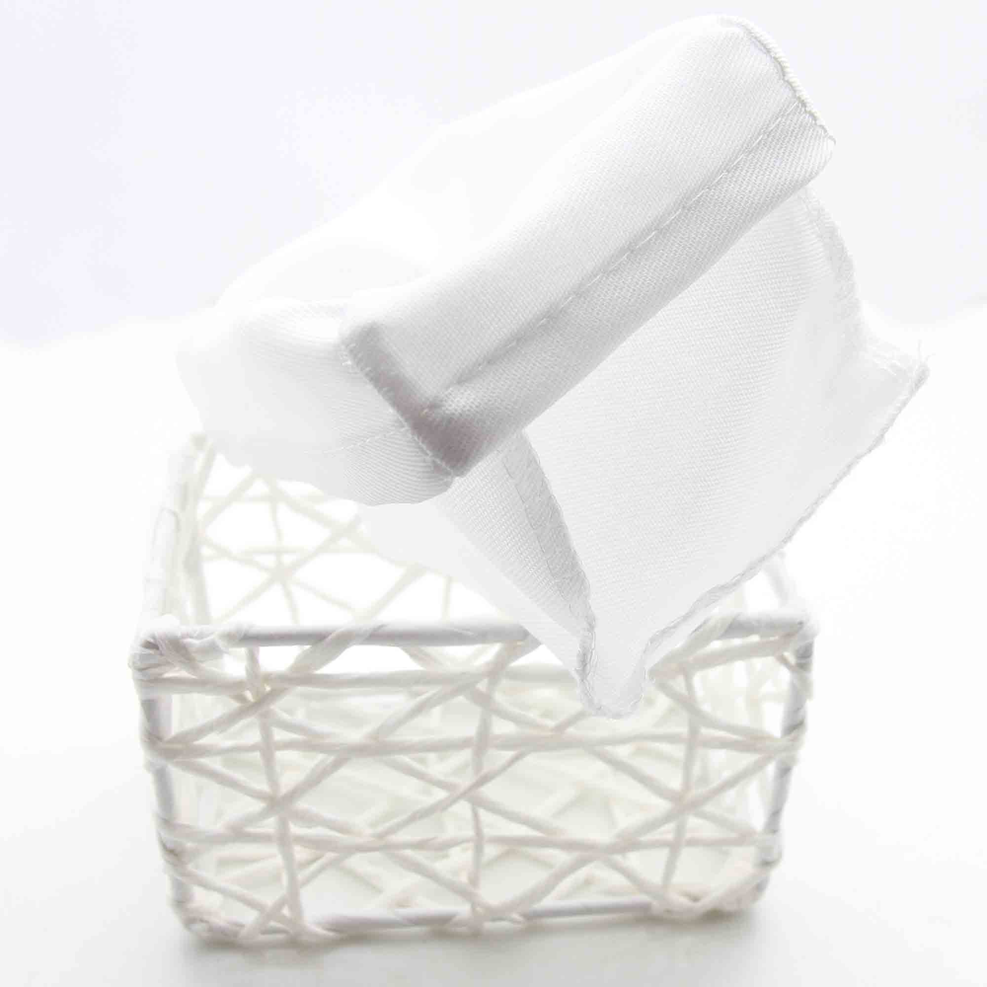 Close-up detail of white paper rope basket's open lattice weave pattern with removable white linen liner being removed.