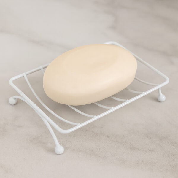 White wire soap dish holding oval cream-colored bar soap on neutral countertop