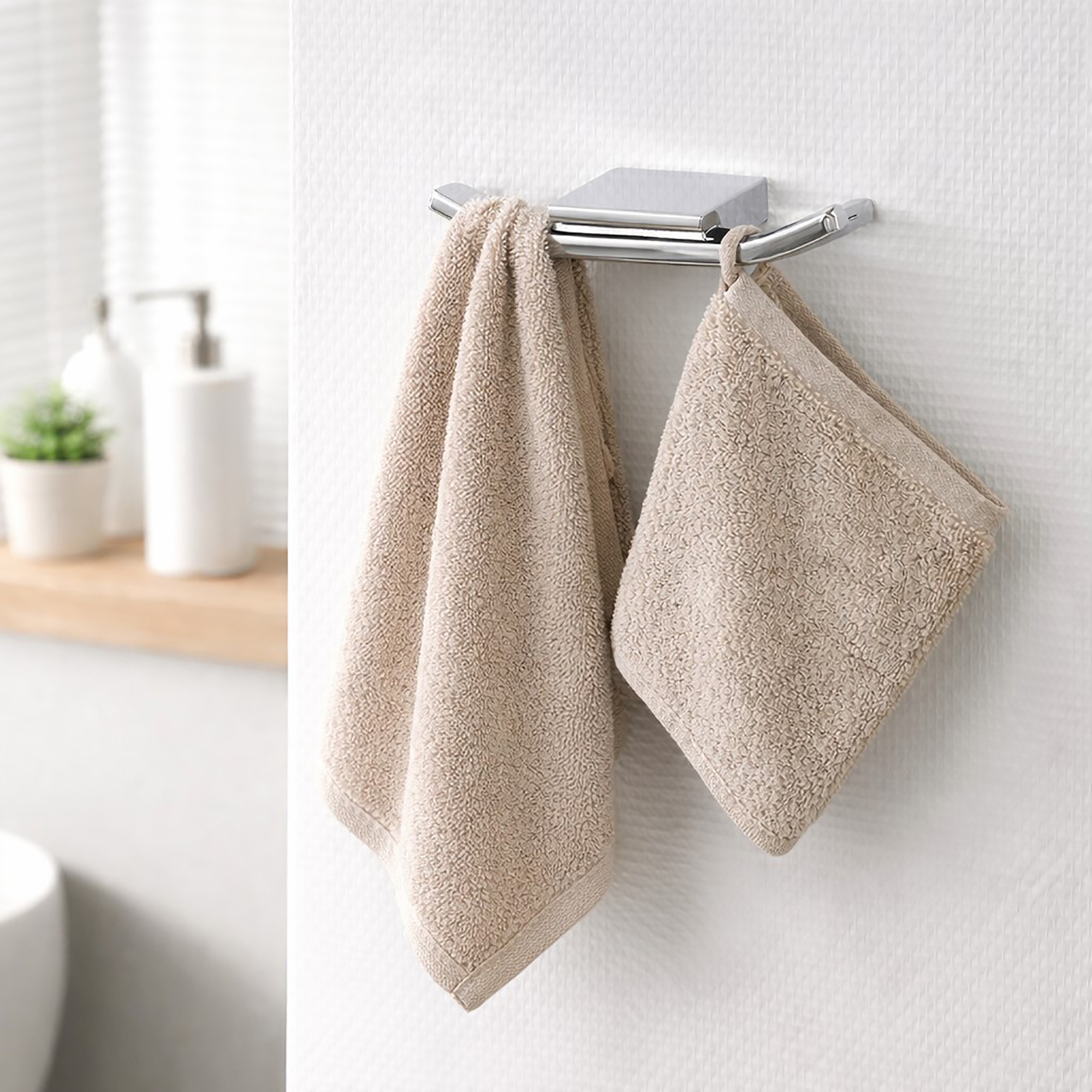 "Chrome double wall hook holding two beige towels in bathroom"