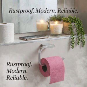 "Chrome toilet paper holder with pink roll in styled bathroom, labeled rustproof, modern, reliable"