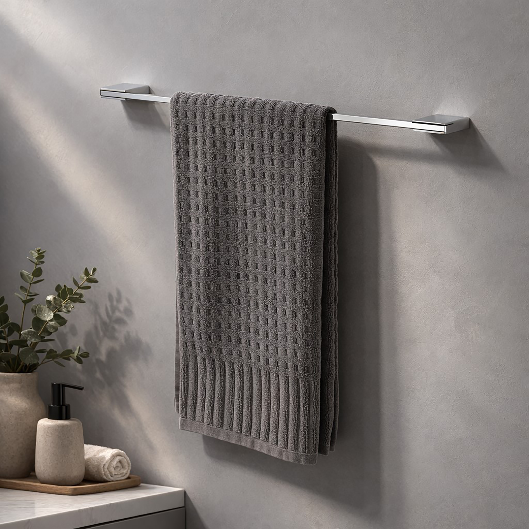 "Chrome 24-inch towel bar with gray waffle towel mounted on gray wall in styled bathroom"