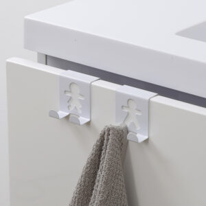 "Two white figure-shaped over-cabinet hooks on white drawer with gray towel hanging from one"