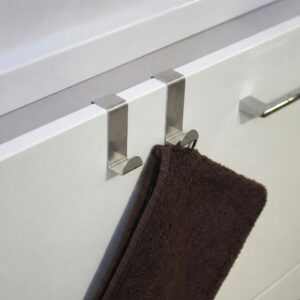 "Two stainless steel hooks on white cabinet door holding a brown towel"