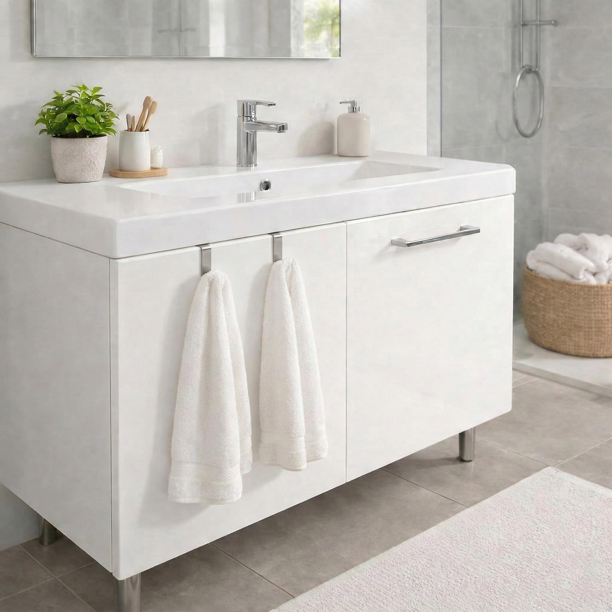 "Two white towels hanging from stainless steel hooks on bathroom vanity cabinet"
