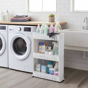 White 3-tier rolling cart holding laundry products between a front-load washer and utility sink in a laundry room