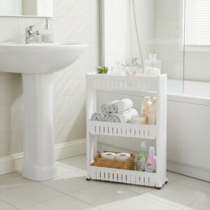 White 3-tier rolling cart holding rolled towels, bath products, and toilet paper in a white bathroom