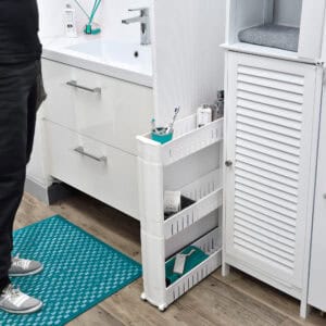 White 3-tier slim rolling cart holding toiletries, tucked between a bathroom vanity and storage cabinet