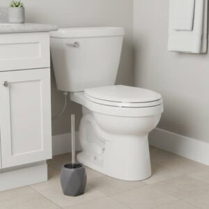 Gray diamond-shaped stoneware toilet brush with stainless steel handle beside white toilet in modern bathroom