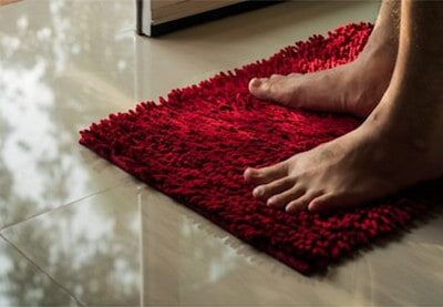 bathroom-mat-men-foot-on-red-doormat