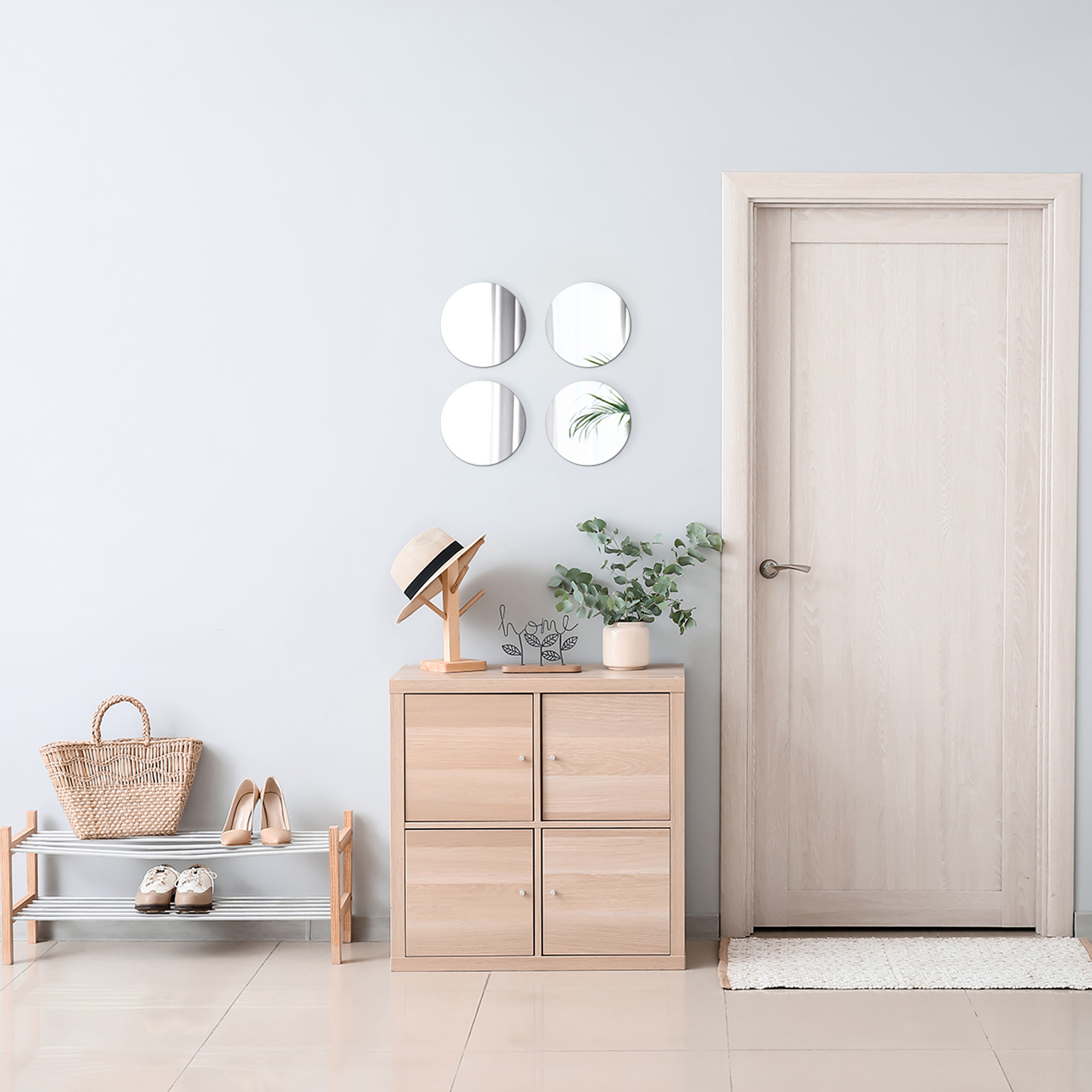 "Four small round wall mirrors above a wooden cabinet in a hallway entryway"