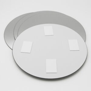 "Back of round mirror showing four adhesive foam mounting pads"