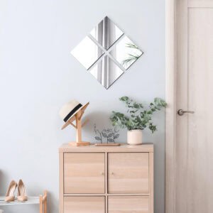 "Four square mirrors arranged in diamond pattern above a wooden cabinet in a hallway entryway"
