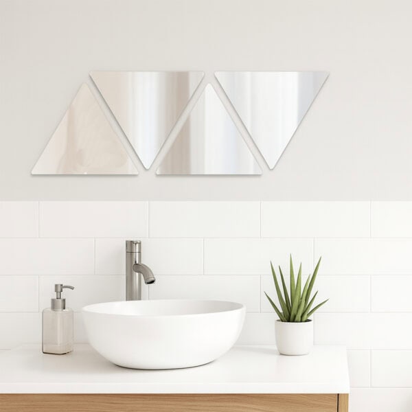 "Four triangle mirrors in alternating up-down row above a white vessel sink in a modern bathroom"