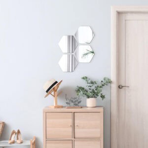 "Four hexagonal mirrors in honeycomb cluster above a wooden cabinet in a hallway entryway"
