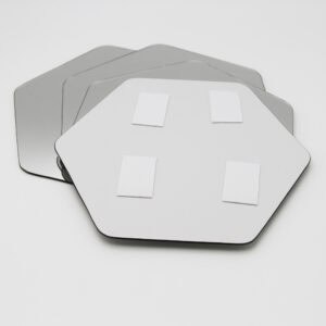 "Back of hexagonal mirror showing four adhesive foam mounting pads, with three additional mirrors stacked behind"